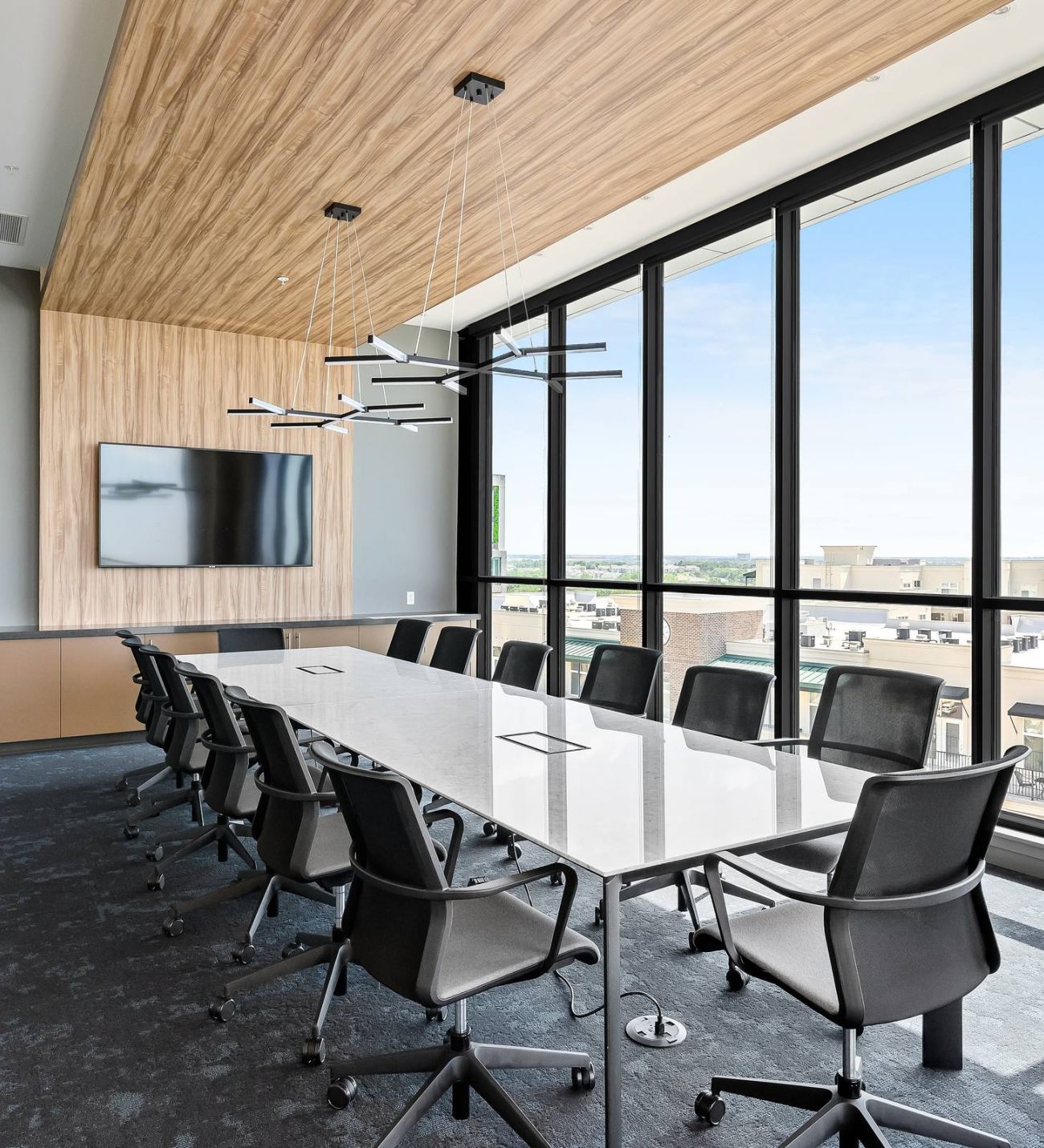 The District Flats apartment community meeting room with long conference table, chairs, and floor to ceiling windows