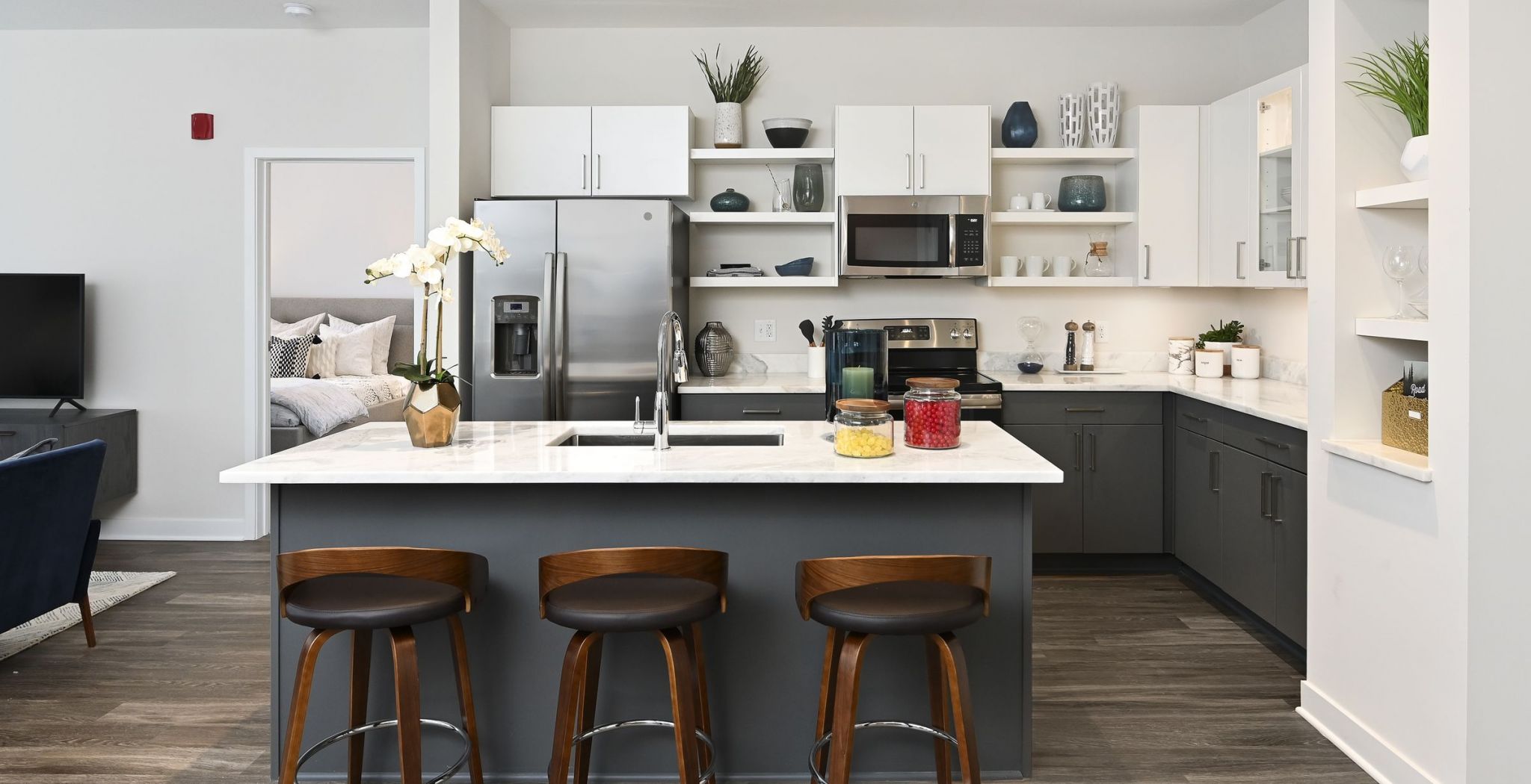 The District Flats apartment kitchen with large island including marble countertop and stainless steel appliances